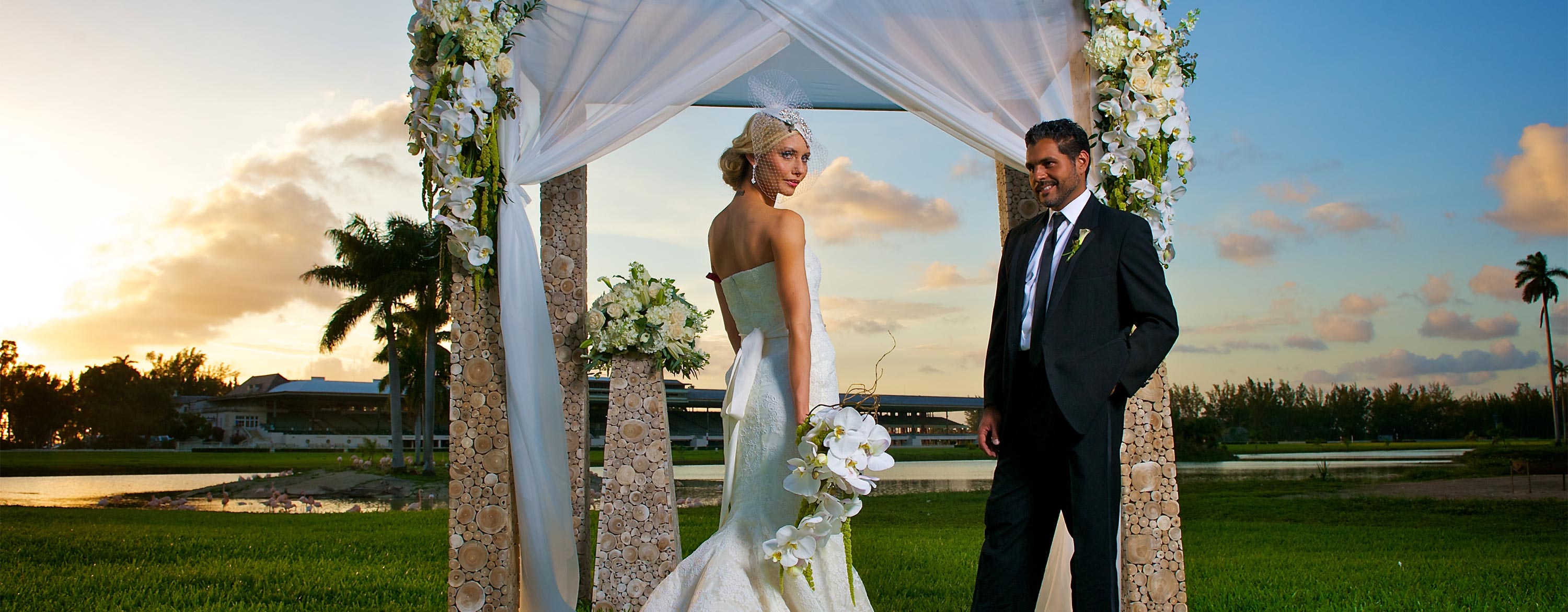 A couple standing in front of a floral arch on their wedding day