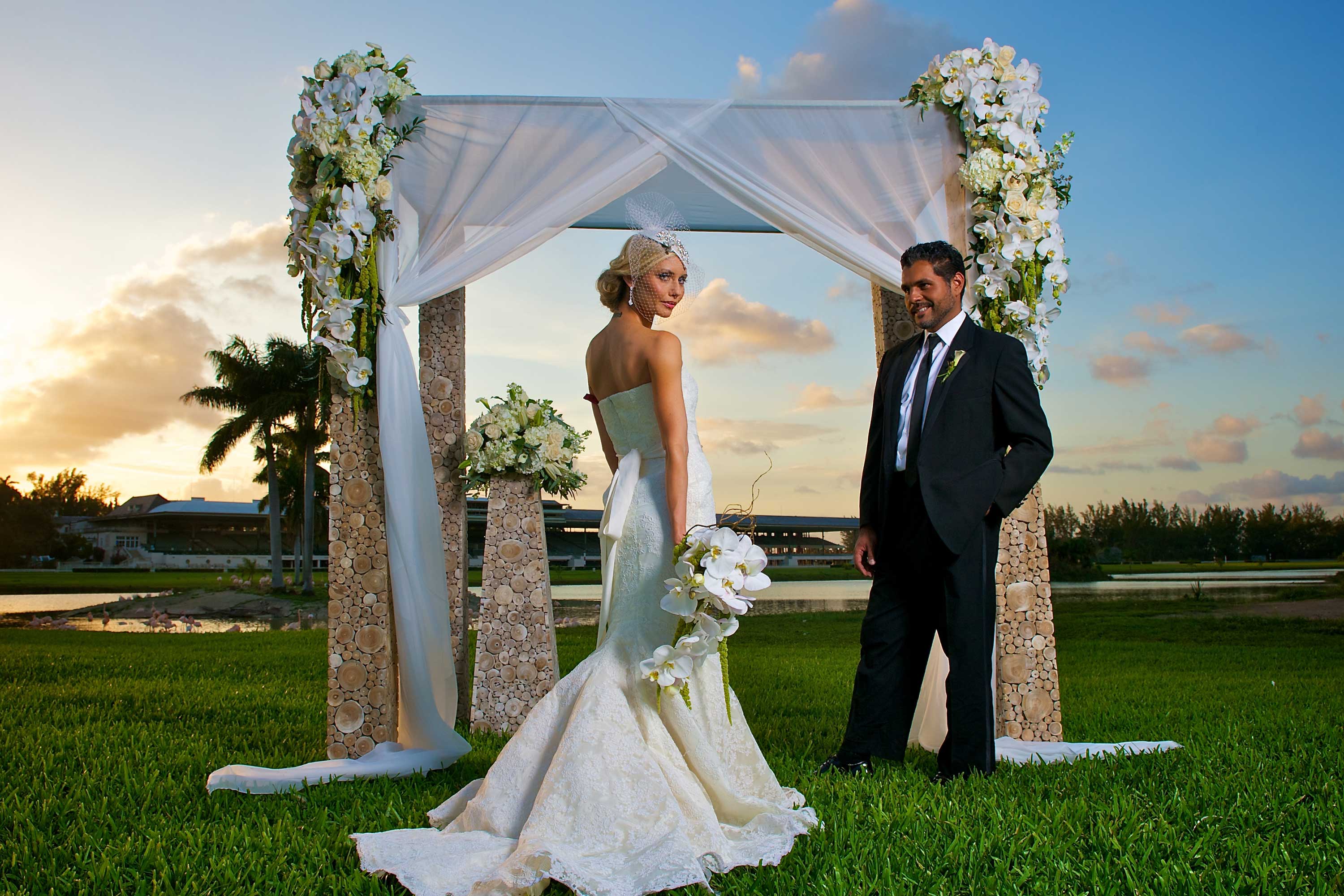 Couple standing in front of an arch at their wedding