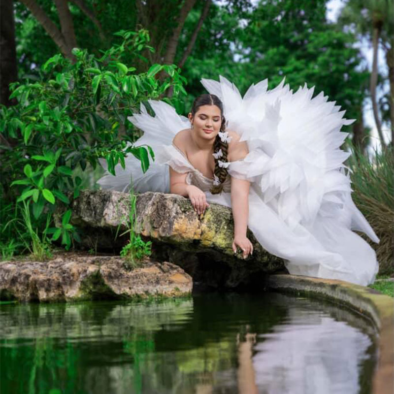 Woman in white dress reflected over water